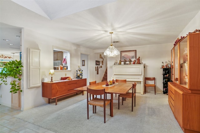 carpeted dining space with a notable chandelier