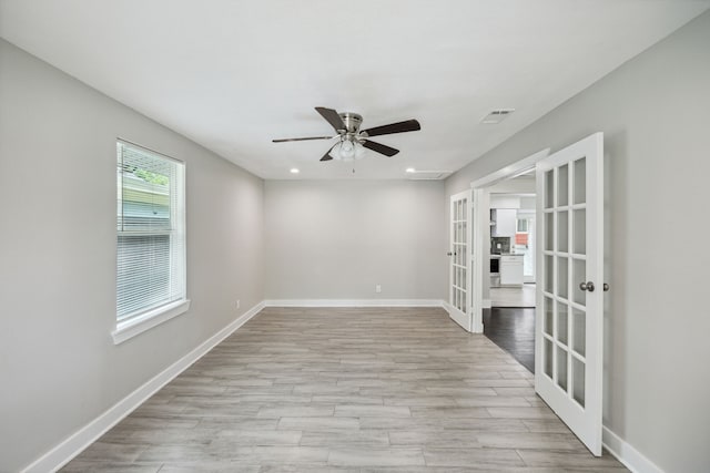 spare room with french doors, light hardwood / wood-style floors, and ceiling fan