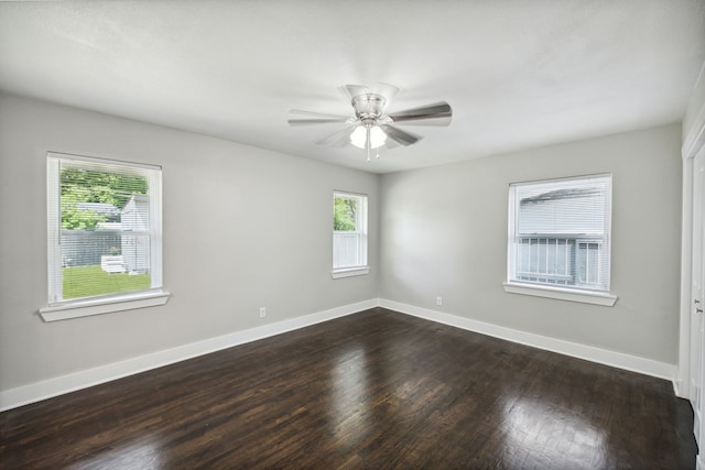 empty room with ceiling fan, plenty of natural light, and dark hardwood / wood-style floors