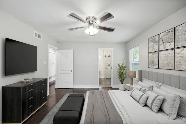 bedroom with dark wood-type flooring, ceiling fan, and ensuite bath