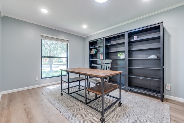 home office with light hardwood / wood-style flooring and crown molding