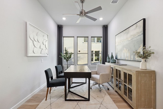 dining space with ceiling fan and light wood-type flooring