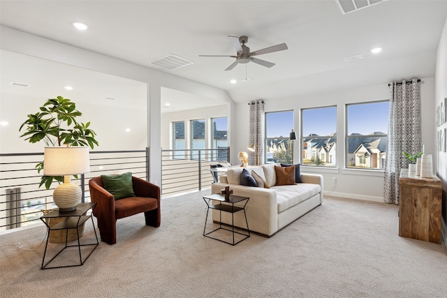 living room with light colored carpet, a water view, and ceiling fan