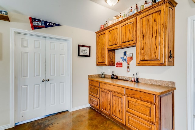 565 Turkey Ridge Rd, Stephenville, TX 76401 - kitchen featuring finished concrete flooring, brown cabinetry, baseboards, and light countertops