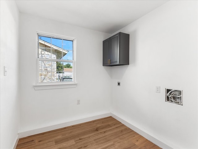 washroom featuring cabinets, electric dryer hookup, and hardwood / wood-style flooring