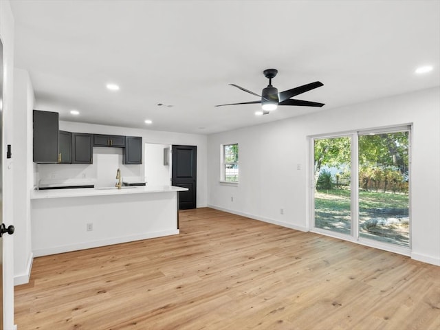 kitchen with sink, ceiling fan, light wood-type flooring, and plenty of natural light