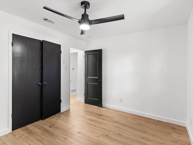 unfurnished bedroom with ceiling fan, light hardwood / wood-style flooring, and a closet