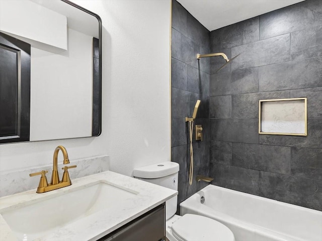 full bathroom featuring tiled shower / bath combo, vanity, and toilet