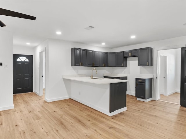 kitchen featuring kitchen peninsula, light hardwood / wood-style flooring, and sink