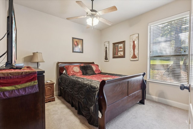 carpeted bedroom featuring multiple windows and ceiling fan