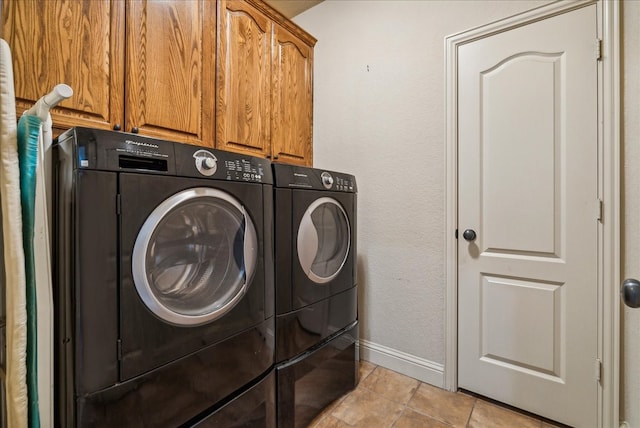 washroom with cabinets, washer and dryer, and light tile patterned flooring