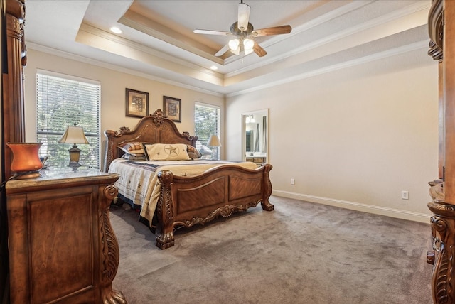 bedroom with carpet flooring, a tray ceiling, ceiling fan, connected bathroom, and crown molding