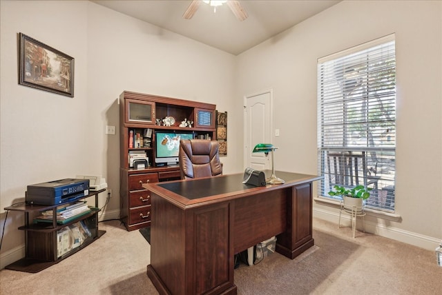 carpeted home office featuring ceiling fan