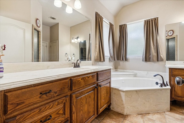 bathroom featuring vanity, lofted ceiling, tile patterned flooring, and tiled tub