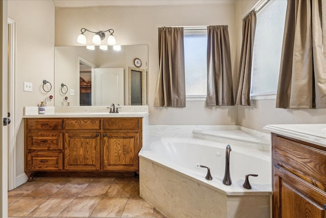 bathroom with vanity, a relaxing tiled tub, and tile patterned flooring