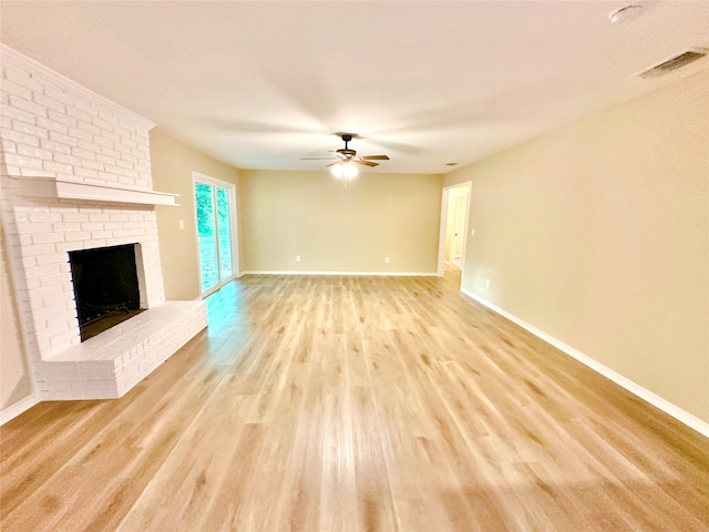 unfurnished living room with a fireplace, light wood-type flooring, and ceiling fan