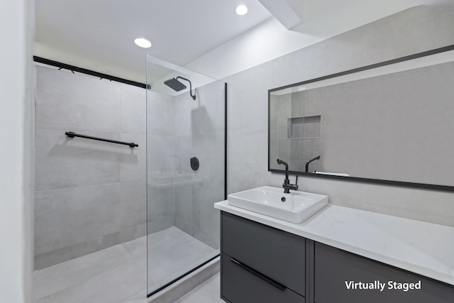 bathroom with vanity and a tile shower