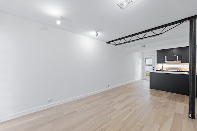 unfurnished living room with light wood-type flooring and sink