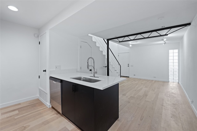 kitchen featuring kitchen peninsula, light hardwood / wood-style floors, stainless steel dishwasher, and sink