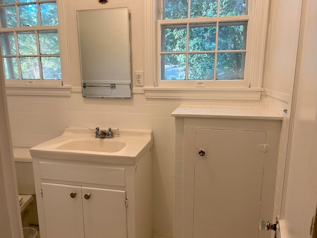 bathroom featuring vanity, tile walls, and a healthy amount of sunlight