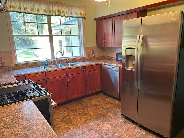 kitchen featuring stainless steel appliances, sink, and backsplash