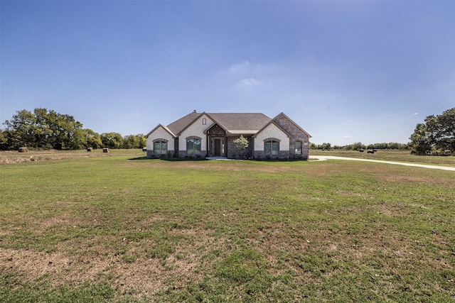 french country home featuring a front lawn