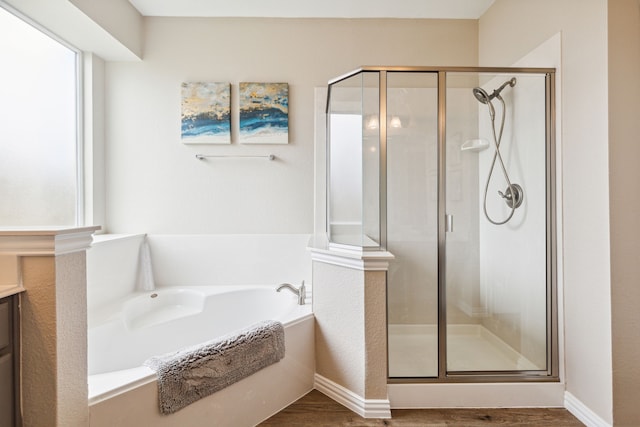 bathroom featuring vanity, plus walk in shower, and wood-type flooring