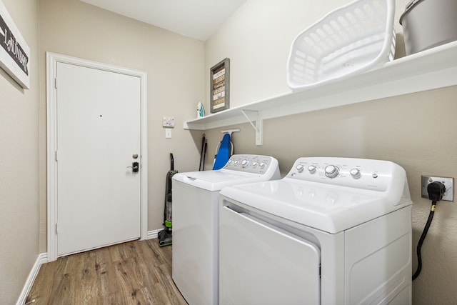 clothes washing area featuring light hardwood / wood-style flooring and washer and dryer