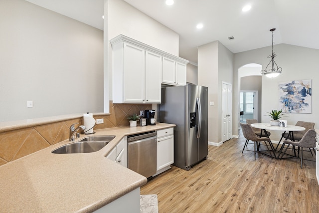 kitchen with light hardwood / wood-style flooring, sink, white cabinets, vaulted ceiling, and appliances with stainless steel finishes