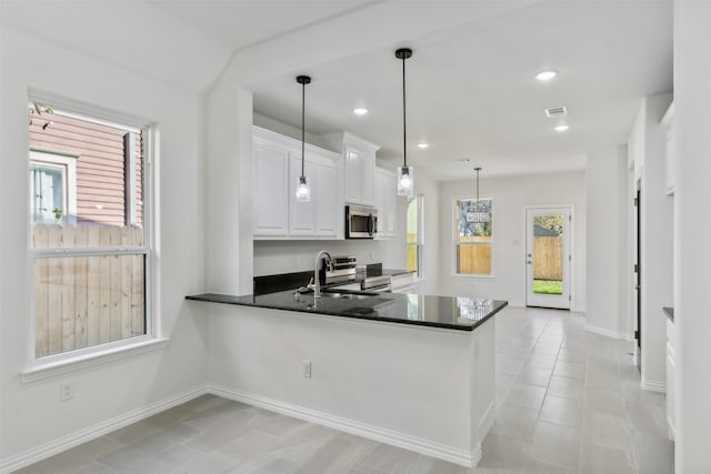 kitchen featuring sink, kitchen peninsula, decorative light fixtures, white cabinetry, and stainless steel appliances