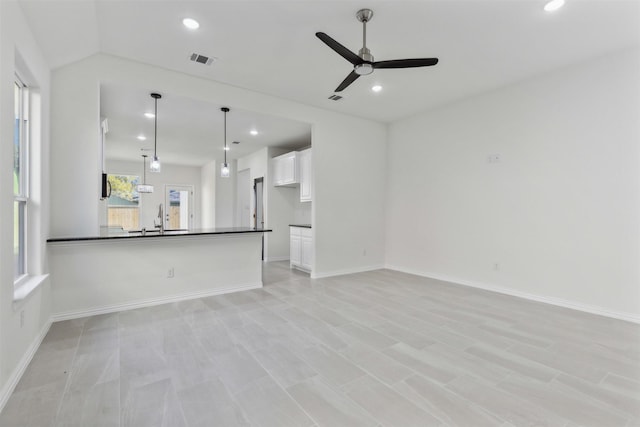 unfurnished living room with recessed lighting, visible vents, a sink, and baseboards