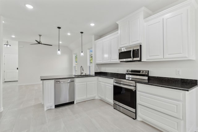 kitchen with hanging light fixtures, appliances with stainless steel finishes, white cabinetry, a sink, and a peninsula