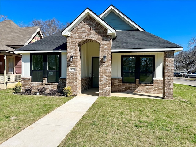 view of front facade featuring a shingled roof, french doors, and brick siding