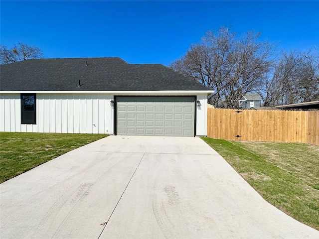 view of property exterior with roof with shingles, a lawn, driveway, and fence