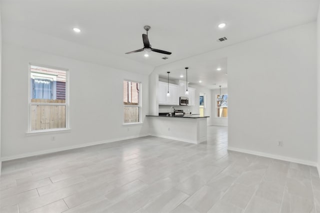 unfurnished living room with visible vents, recessed lighting, a ceiling fan, and baseboards