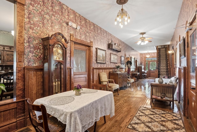 dining room featuring wood-type flooring and ceiling fan with notable chandelier