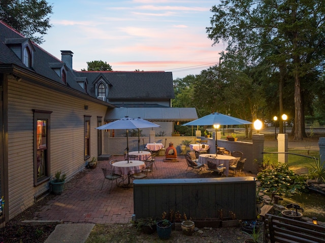 patio terrace at dusk featuring a fire pit