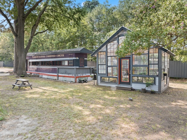 rear view of house featuring a yard and an outbuilding