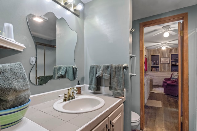 bathroom featuring vanity, hardwood / wood-style floors, toilet, and a shower with door