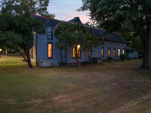 view of front facade featuring central AC and a lawn