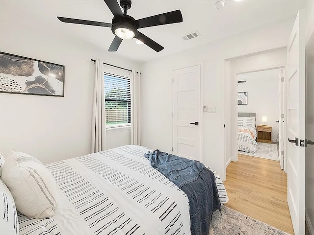 bedroom with ceiling fan and light hardwood / wood-style floors