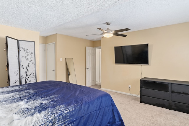 carpeted bedroom with ceiling fan and a textured ceiling