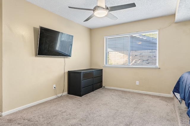 bedroom with a textured ceiling, light colored carpet, and ceiling fan