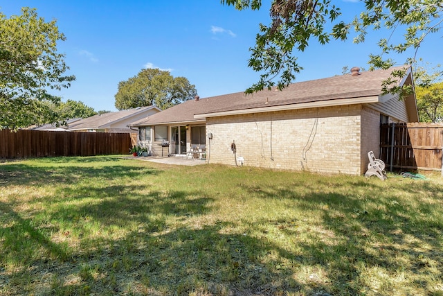 rear view of house featuring a patio and a lawn