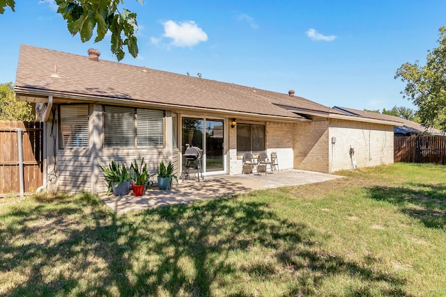 rear view of property featuring a patio area and a lawn