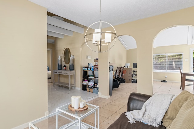 tiled living room featuring a notable chandelier and a textured ceiling