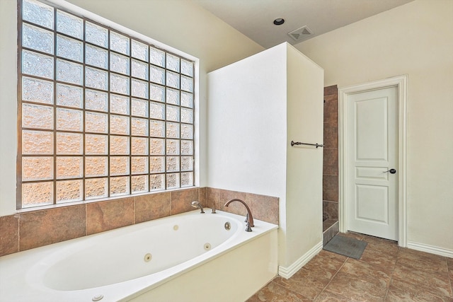 bathroom with tile patterned flooring and a bathtub