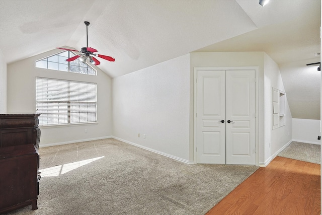 unfurnished living room featuring a textured ceiling, ceiling fan, hardwood / wood-style floors, and lofted ceiling