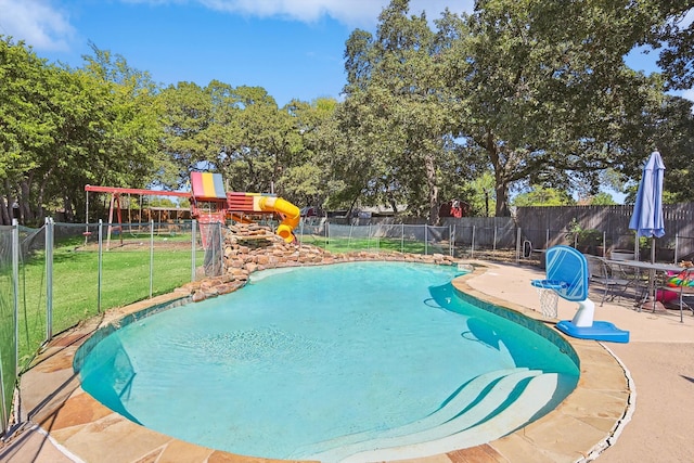 view of pool with a playground, a yard, and a patio