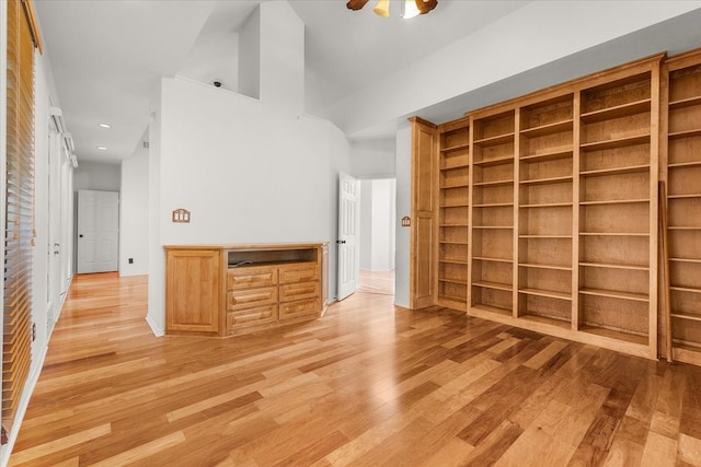 interior space featuring built in desk, high vaulted ceiling, light wood-type flooring, and ceiling fan